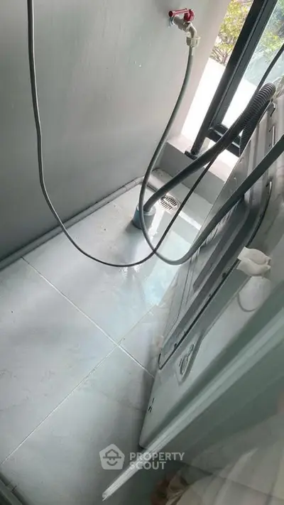 Compact laundry area with washing machine and window view
