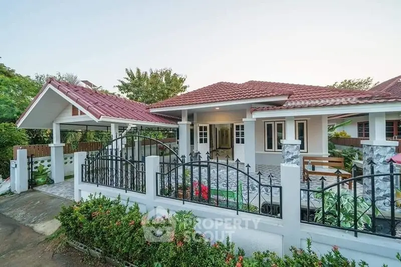 Charming single-story house with red roof, spacious driveway, and lush garden, perfect for family living.