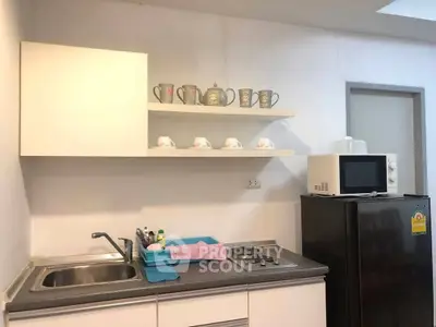 Compact kitchen with modern appliances and open shelving for stylish storage.