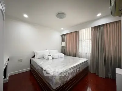 Spacious bedroom with elegant decor and natural light, featuring a large comfortable bed and stylish curtains.