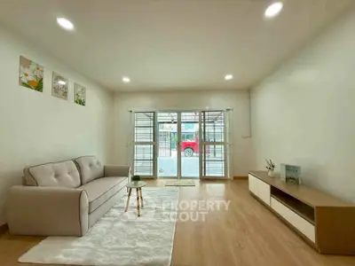Spacious living room with modern decor and large window for natural light.