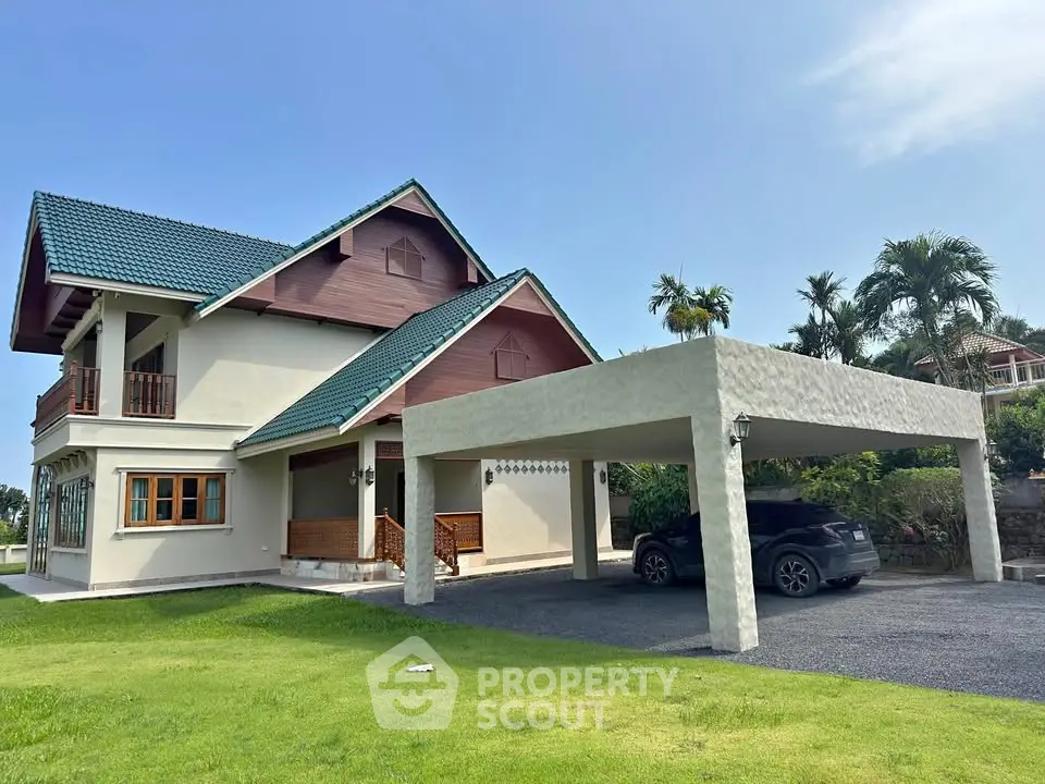 Charming two-story house with carport and lush green lawn, featuring a classic design and serene surroundings.
