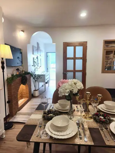 Charming dining room with elegant table setting and cozy fireplace in a stylish home interior.