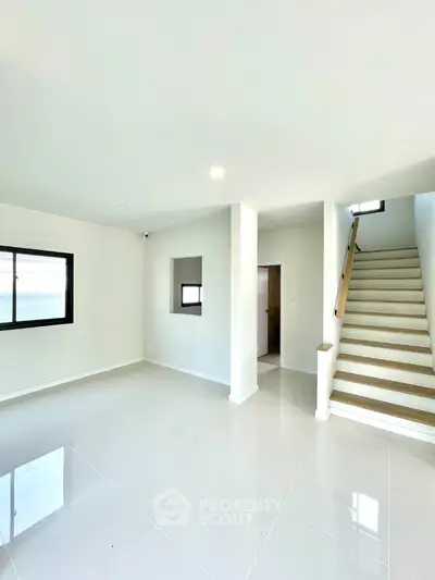 Spacious modern living room with staircase and large windows