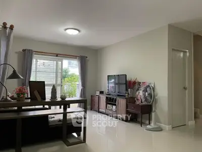 Spacious living room with modern decor and natural light, perfect for relaxation and entertainment.