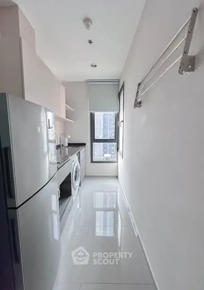 Modern kitchen with sleek appliances and large window offering city view