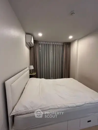 Cozy bedroom with modern decor and soft lighting, featuring a comfortable bed and stylish curtains.