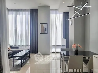 Modern living and dining area with sleek furniture and large windows in a stylish apartment.