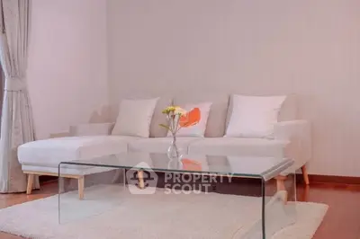 Elegant living room with modern glass coffee table and cozy white sofa