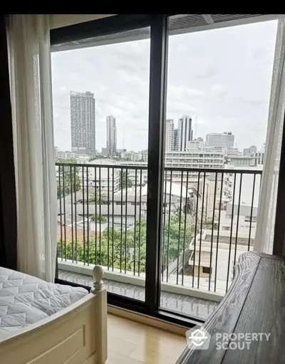 Bright and airy bedroom with large windows offering a stunning cityscape view, perfect for urban living enthusiasts seeking a serene retreat.