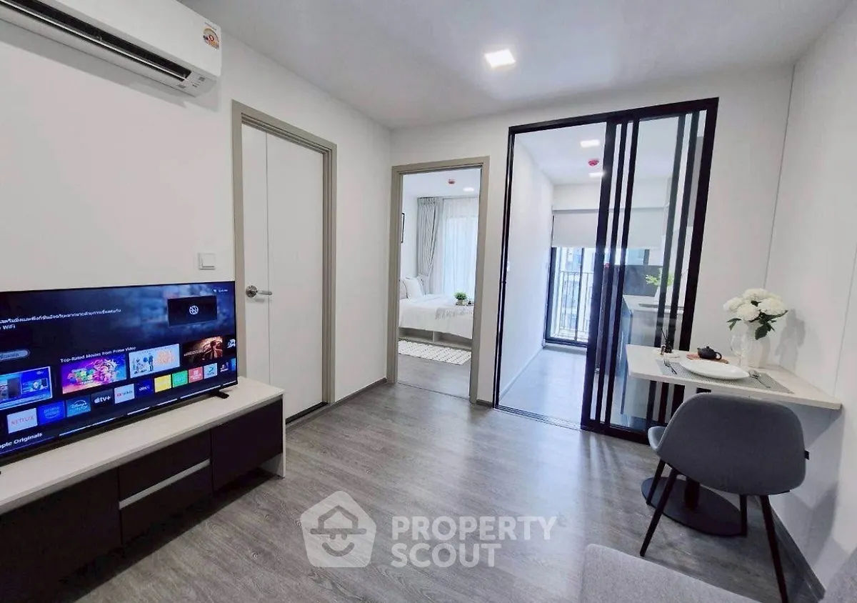 Modern apartment interior with living room and bedroom view, featuring sleek design and natural light.