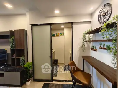 Modern living room with stylish decor and sliding door leading to another room, featuring wall shelves and a clock.
