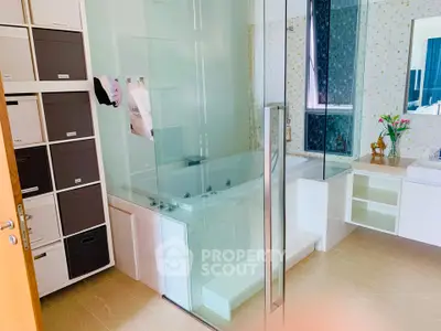 Luxurious bathroom with glass shower and built-in bathtub, featuring modern storage solutions.