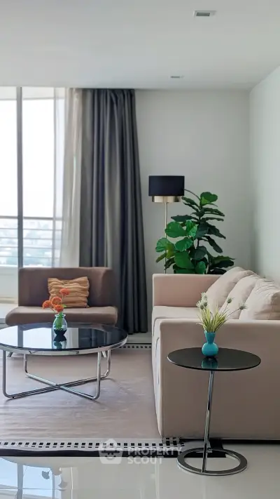 Modern living room with stylish furniture and large window offering natural light.