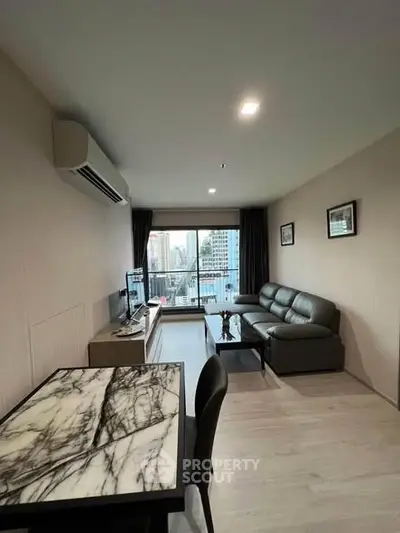 Modern living room with city view, featuring sleek furniture and air conditioning.