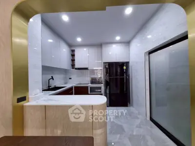 Modern kitchen with sleek cabinetry and marble flooring, featuring an open layout and high-end appliances.