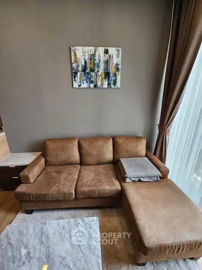 Stylish living room with cozy brown sofa and modern art on wall, perfect for relaxation.