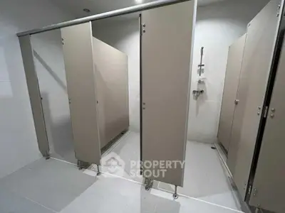 Modern public bathroom stalls with sleek design and privacy partitions.