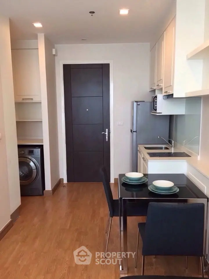 Modern kitchen with dining area and washing machine in compact apartment