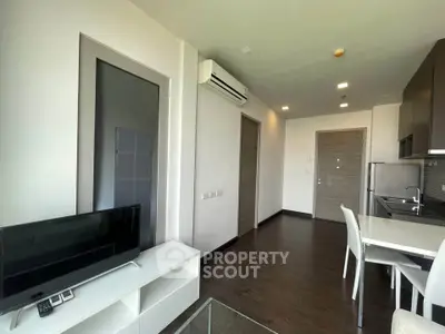 Modern apartment interior with sleek kitchen and cozy living area, featuring hardwood floors and contemporary furniture.