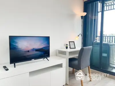 Modern living room with TV and study desk near balcony, bright and airy space.