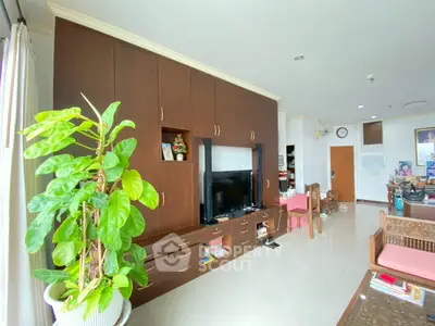 Spacious living room with elegant wooden cabinetry and large windows