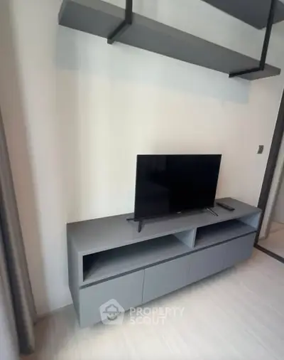 Modern living room with sleek TV stand and mounted shelves, perfect for minimalist decor.