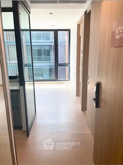 Modern apartment entrance with wooden flooring and glass partitions