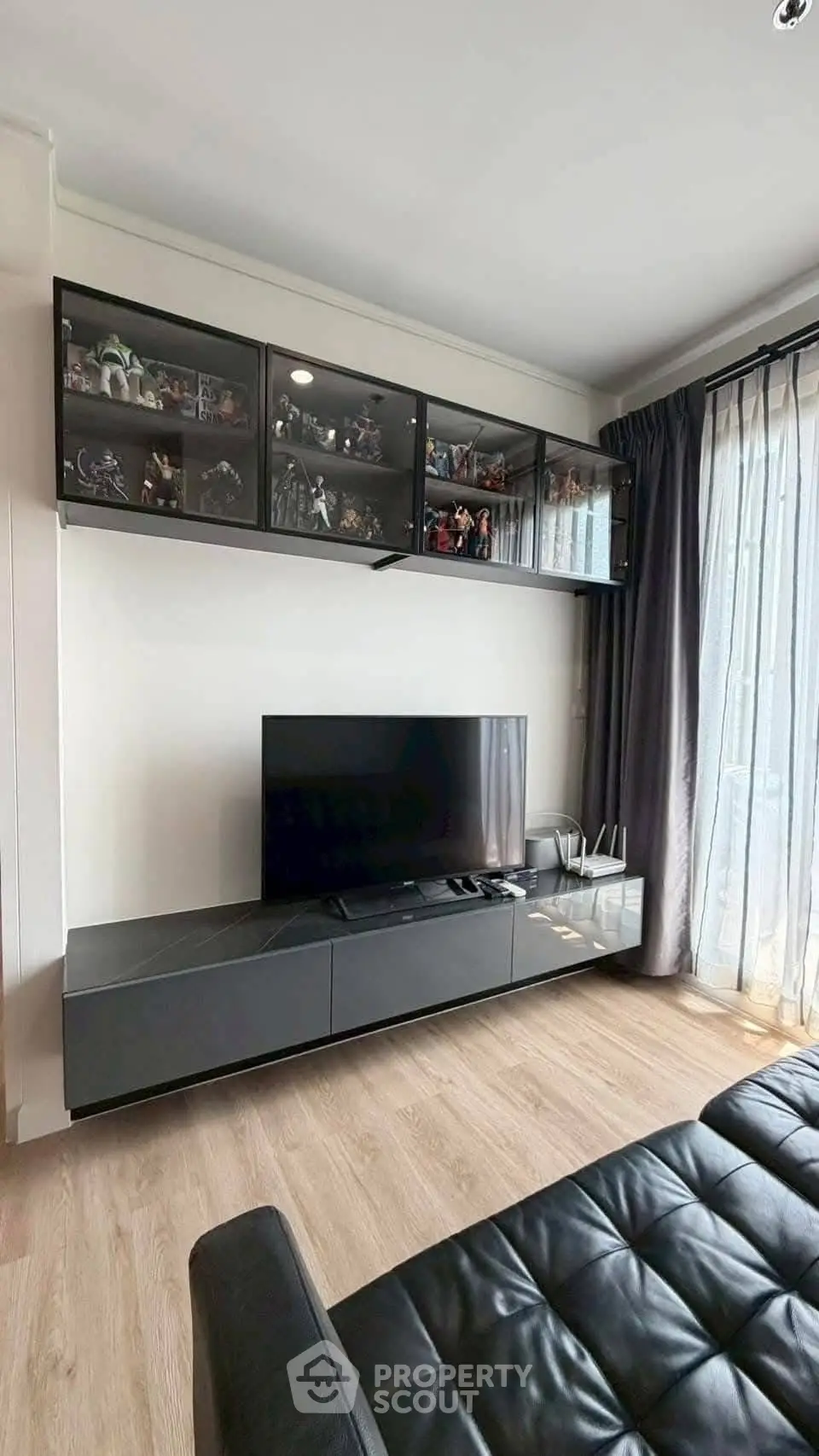 Modern living room with sleek black entertainment unit and glass display cabinets.