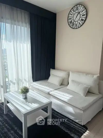 Modern living room with white sofa, black curtains, and stylish clock on wall.