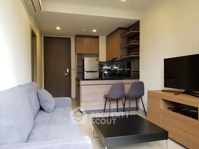 Modern living room with open kitchen and stylish furniture in a cozy apartment.