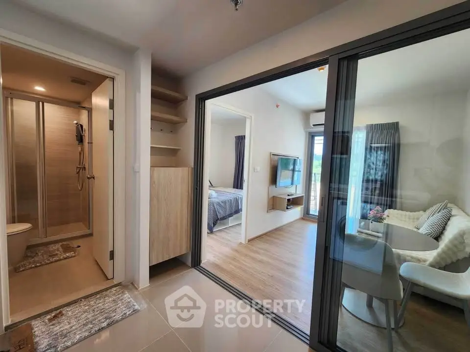 Modern apartment interior with open living area and bedroom view.