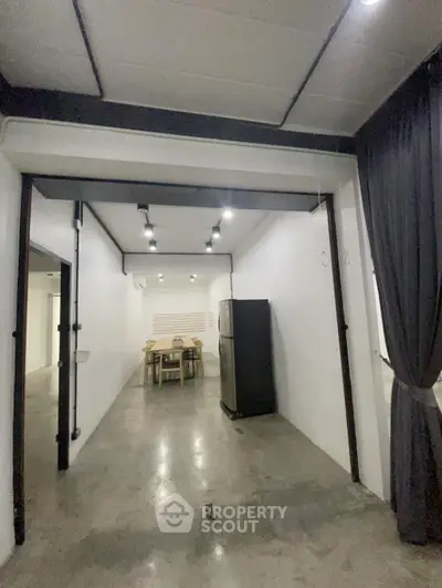 Modern industrial-style interior with polished concrete floors and minimalist dining area.