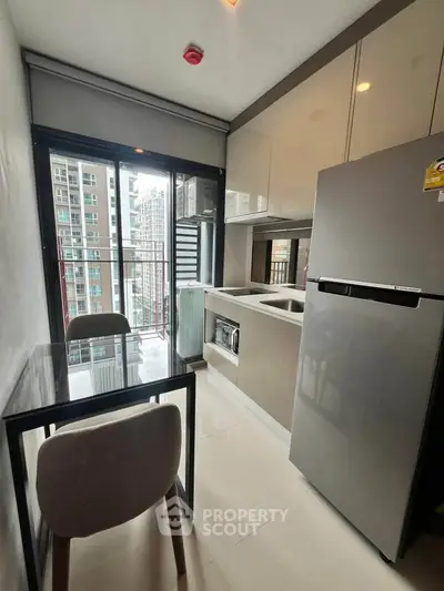 Modern kitchen with sleek appliances and city view from balcony, perfect for urban living.
