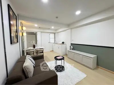 Modern living room with cozy sofa and dining area in open layout apartment.