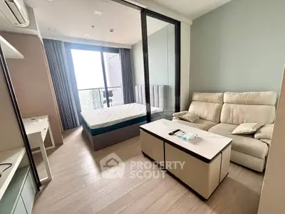 Modern studio apartment with balcony and stylish furnishings, offering a cozy living space with a great view.