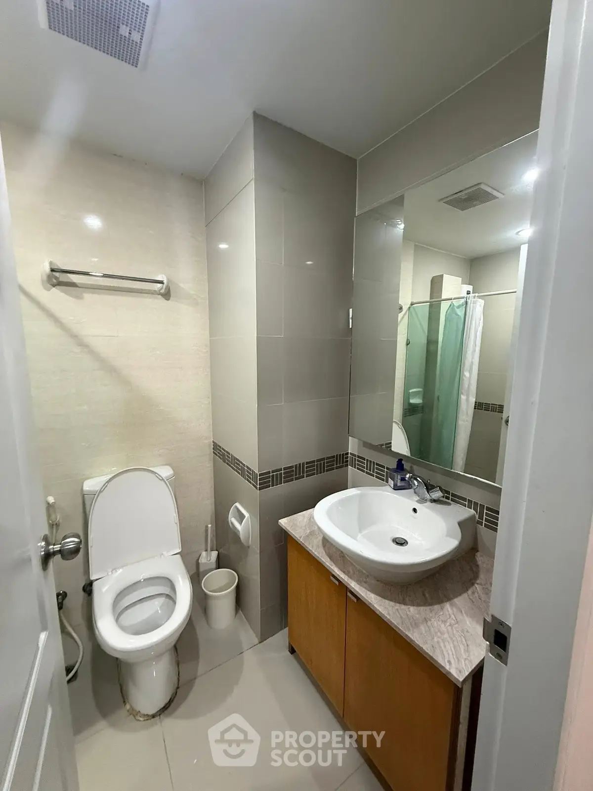 Modern bathroom with sleek fixtures and neutral tones, featuring a spacious shower and elegant vanity.