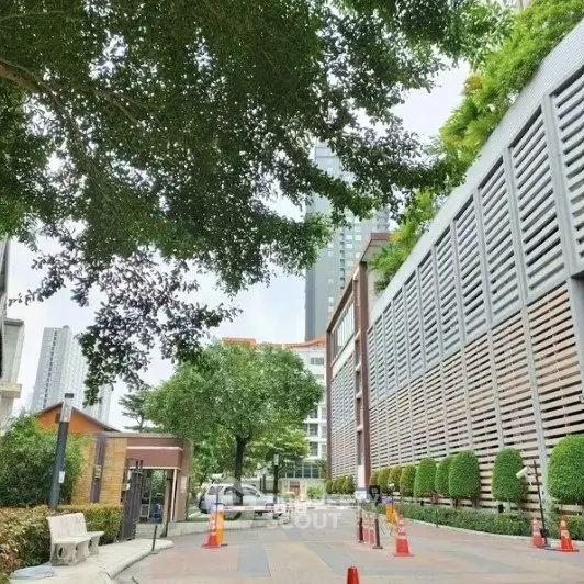 Modern urban building exterior with lush greenery and secure entrance
