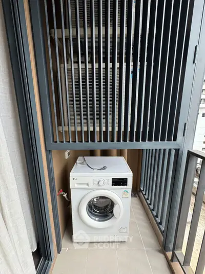 Compact balcony with washing machine and modern railing design.