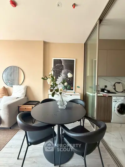 Modern living room with stylish dining area and open kitchen featuring a washing machine.