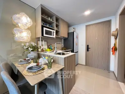 Modern kitchen with dining area, featuring sleek cabinetry, built-in microwave, and stylish decor.