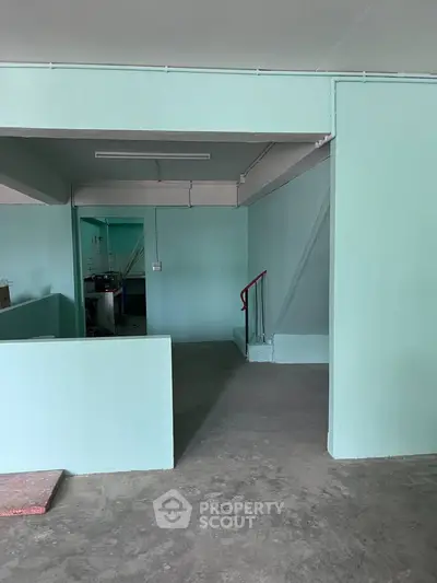 Spacious industrial-style interior with concrete floors and minimalist design.