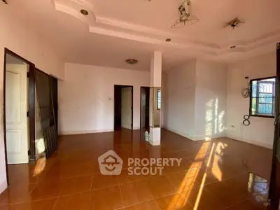 Spacious empty room with tiled flooring and natural light, ideal for customization.