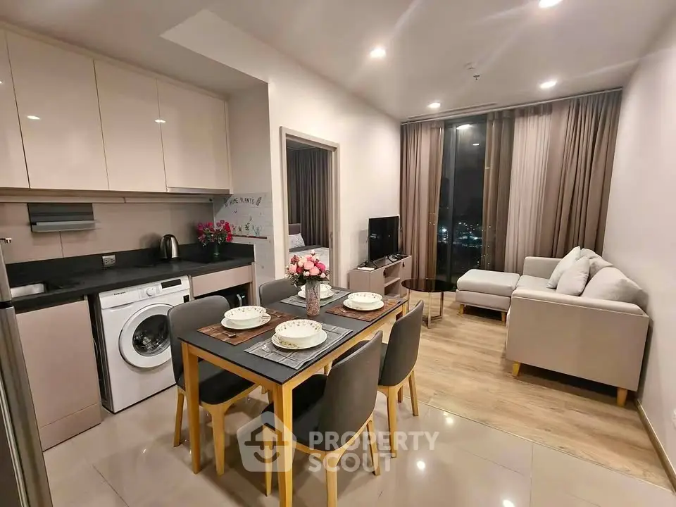 Modern open-plan living room with dining area and kitchen, featuring sleek furniture and city view.