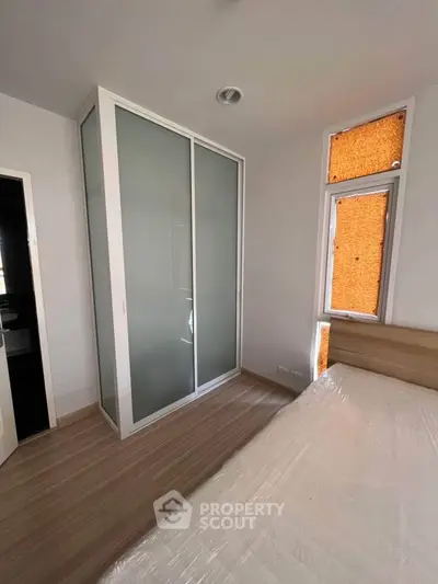 Modern bedroom with sleek sliding wardrobe and natural light