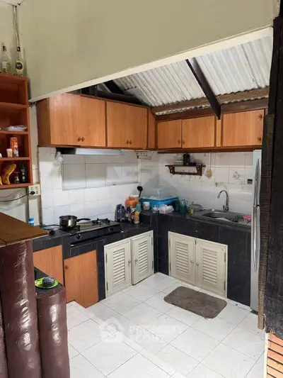 Charming kitchen with wooden cabinets and gas stove, perfect for cozy home cooking.