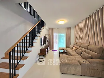 Spacious living room with modern staircase and cozy seating area