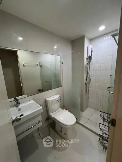 Modern bathroom with glass shower and sleek fixtures in a contemporary apartment.