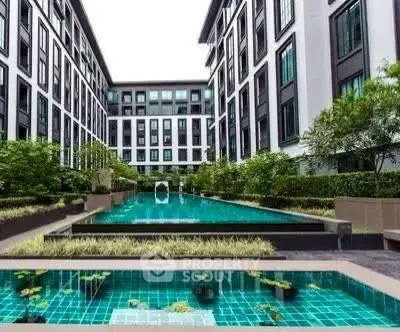 Luxurious apartment complex with stunning pool and lush greenery