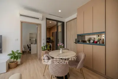 Modern open-plan living area with stylish dining set and wooden cabinetry